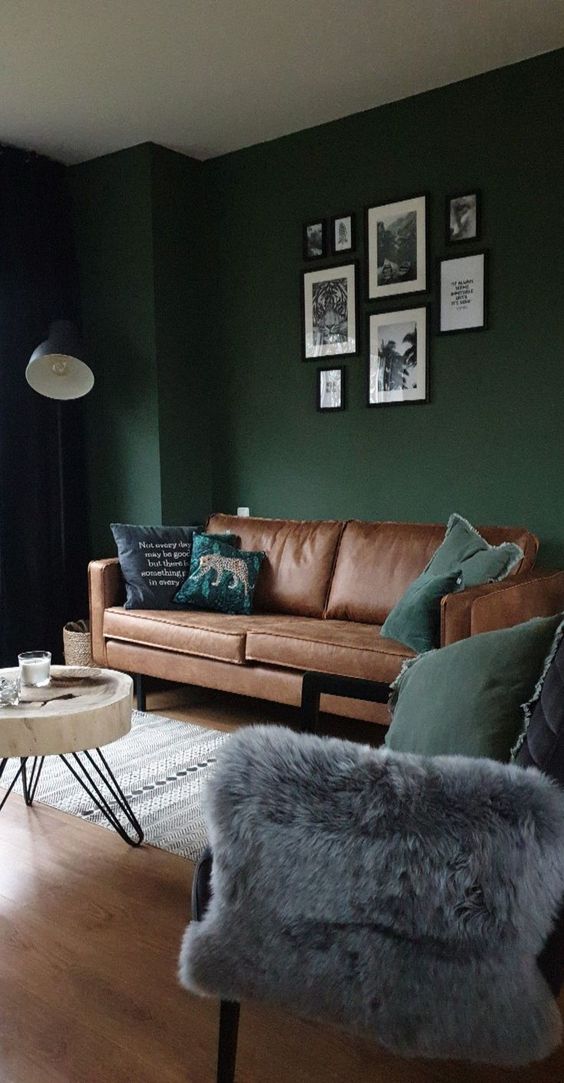 modern living room with dark green wall brown leather sofa blue and green pillows